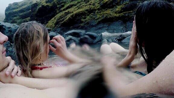 一对年轻夫妇在冰岛的山上泡温泉游客享受天然温泉