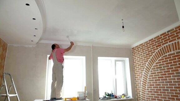 房屋油漆工正在刷厨房天花板