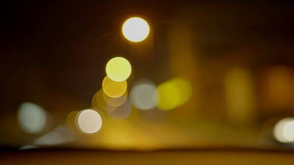 夜间灯光下城市街道上的女司机驾驶汽车