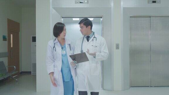 外科医生和一位女医生走过医院的走廊谈论病人的健康状况