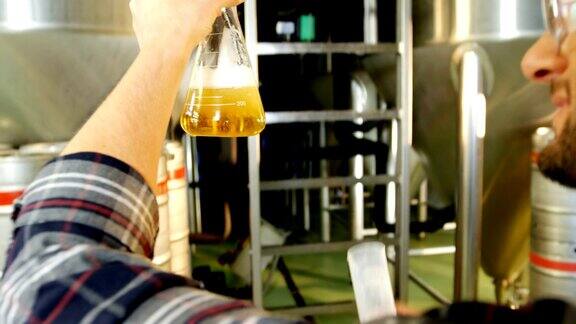 酿酒师将啤酒倒入实验室烧瓶中4k