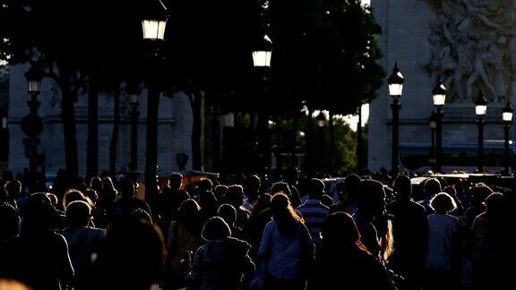 游客们在傍晚的阳光下漫步在香榭丽舍大街上