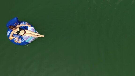 女人骑着充气环在河上漂浮