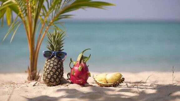在海边的沙滩上放着成熟的菠萝和粉红色的火龙果