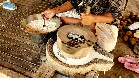 老妇人用手磨米
