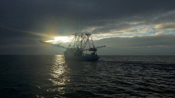 捕虾船在日出时用网捕鱼