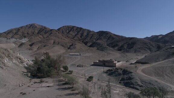 无人机拍摄阿塔卡马沙漠迭戈·德·阿尔马格罗镇乡村上空偏远的城镇在贫瘠的土地上支持采矿活动有树木和房屋的山谷景色