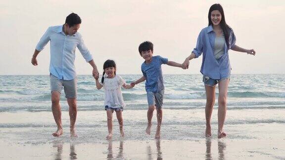 幸福的一家人在海滩上散步快乐的一家人在海滩上享受暑假假期