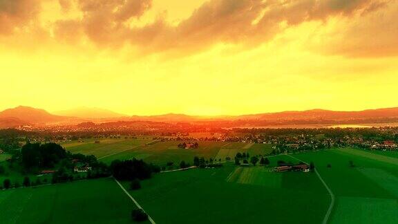令人惊叹的空中日落绿色的欧洲田野金色的天空黄昏在巴伐利亚阿尔卑斯山德国巴伐利亚