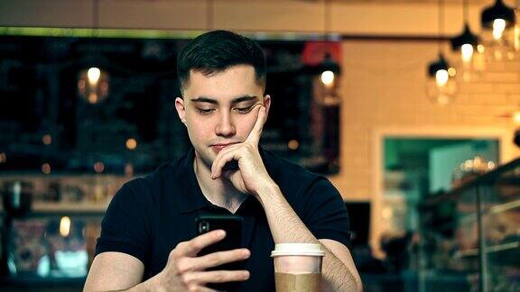 一个年轻人在舒适咖啡店用手机