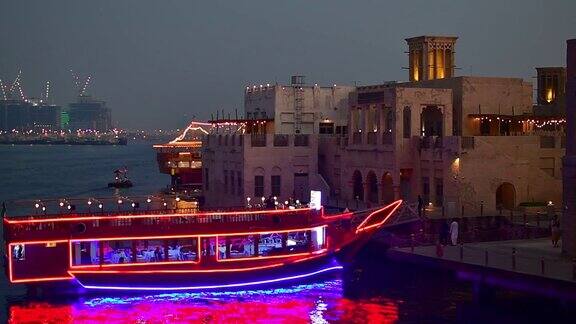 阿联酋迪拜-2022年10月12日:夏季迪拜老河区美丽的老建筑停靠在灯火通明的古船餐厅
