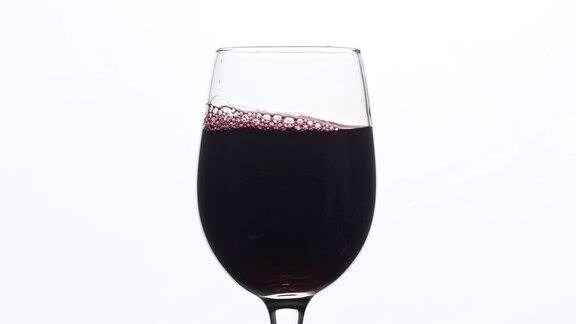 葡萄酒红酒倒入酒杯中背景为白色中心组成