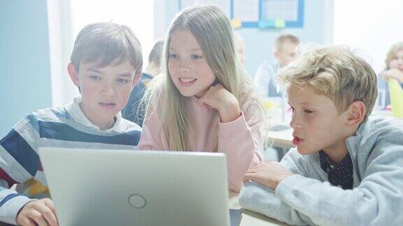 小学课堂:聪明的孩子们用笔记本电脑进行软件编程、交谈和团队合作学习软件设计和创造性思维的孩子