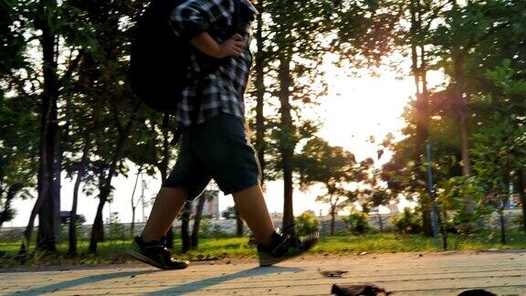 亚洲孩子背着背包在公园里散步和晒太阳