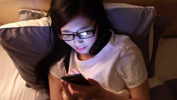 亚洲女性在床上使用智能手机