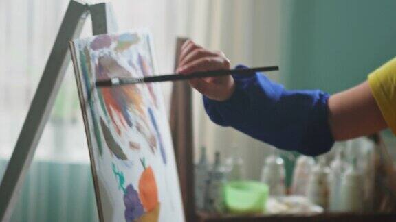 穿蓝围裙的孩子正在画画