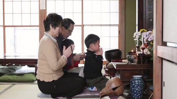 日本多代家庭在家庭佛坛前祈祷