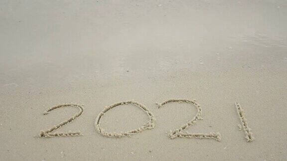 2022年新年快乐2021年写在沙滩上海浪飞溅到2022年新年倒计时从2021年到2022年视频素材背景