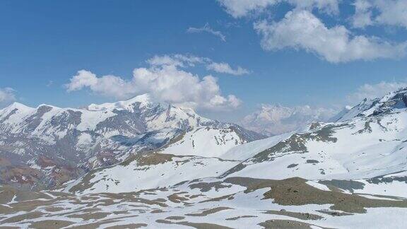 高原全景蓝天中白色的山峰触云地面上白雪皑皑的图案