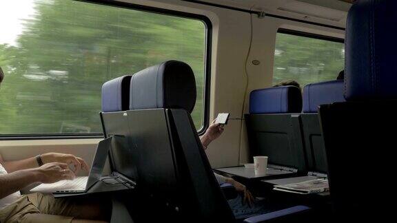 人们在火车上用手机和笔记本电脑娱乐