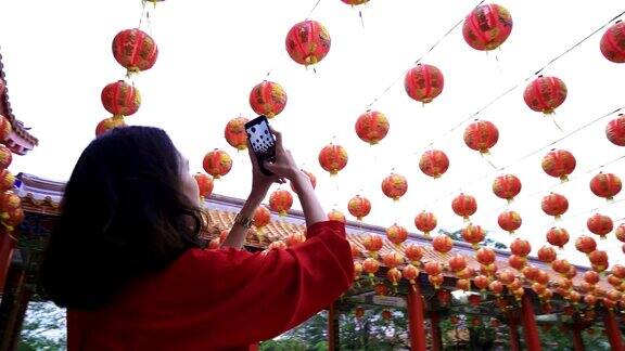 女人拍照的许多中国灯笼在神社