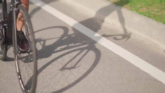 影子亚洲的中国夫妇在周末早上一起骑公路自行车