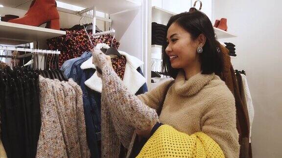 亚洲女人在商场购物买圣诞礼物买衣服(所有品牌都模糊了)