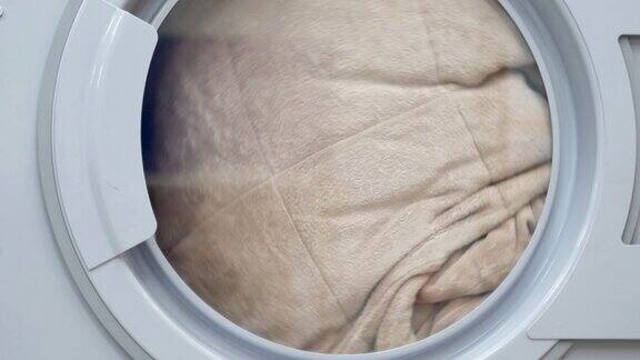 晾晒的衣服烘干机关闭工业洗衣机的特写在烘干机内均匀转动干衣机洗衣机洗衣服洗衣服