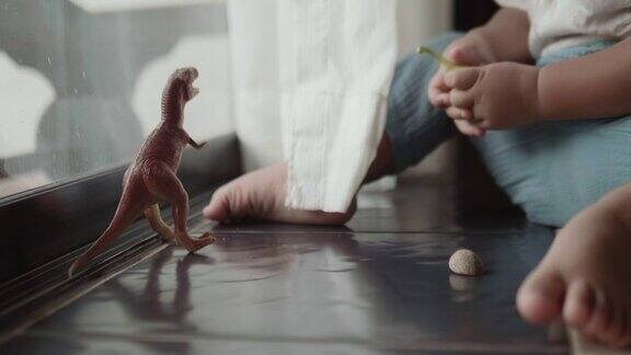 亚洲小男孩在房间里玩玩具恐龙