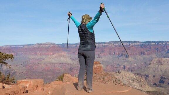 在大峡谷的顶端一名女性游客举起了她成功的手臂