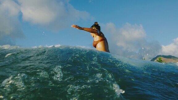 年轻女子在日落时冲浪