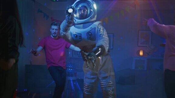 有趣的家伙穿着太空服在霓虹灯下跳舞