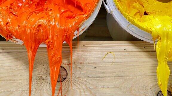 蓝色、黄色、橙色和红色的印刷t恤油墨从桶中流出