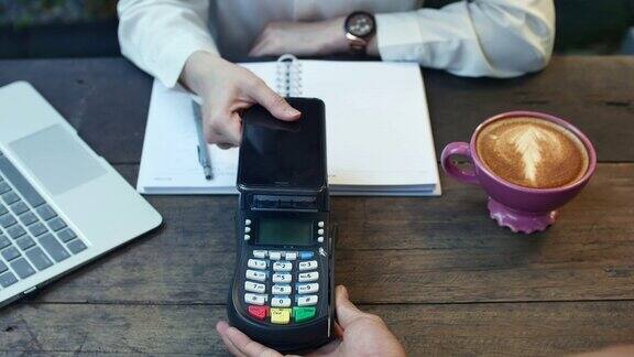 顾客在咖啡厅用智能手机进行非接触式支付