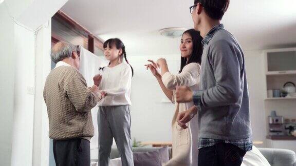 4K超高清手持:快乐的亚洲多代家庭一起在客厅跳舞