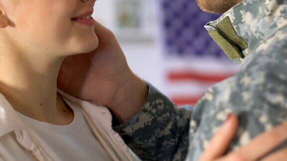 年轻的妻子微笑着拥抱着穿着迷彩服的丈夫士兵回家