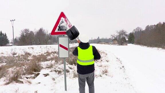 工人正在清理道路附近积雪的警告标志