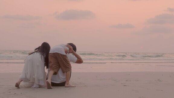 日落时分兄弟姐妹跑到海滩上拥抱他们的父母快乐的亚洲家庭理念