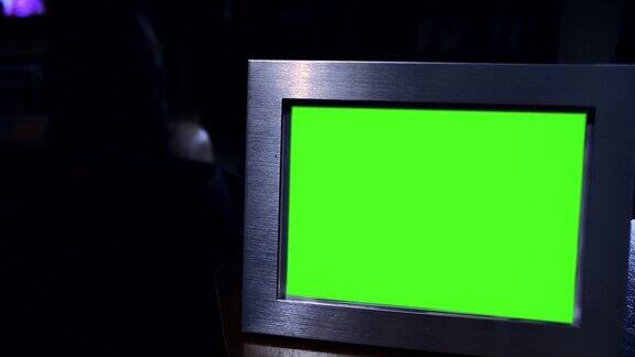 在黑暗中装有绿色屏幕的相框放大