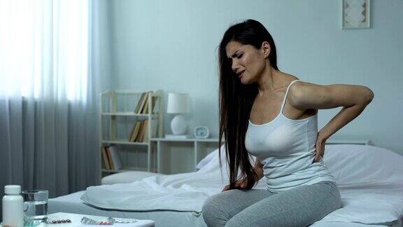女性在床上时遭受严重的背部疼痛造成受伤的后果
