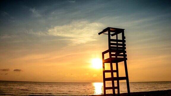 夏日日落时在美丽的海滩上坐着一把椅子