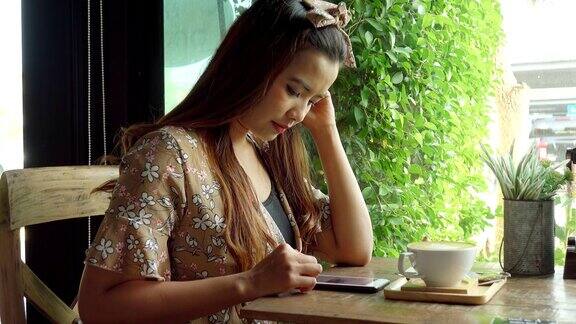 亚洲女性在咖啡馆使用智能手机