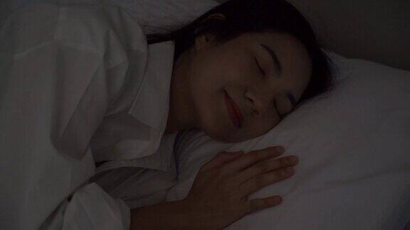 幸福的年轻女子睡在床上