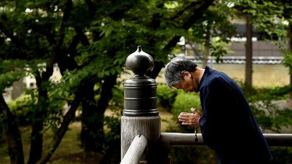 一名日本老人在寺庙里祈祷