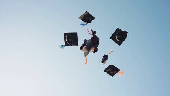 一群毕业生把他们的帽子抛向天空以祝贺他们毕业