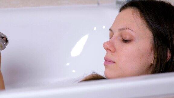 女人正在洗澡她从淋浴器里往身上倒水