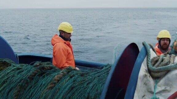 一队渔民在商业捕鱼期间解开拖网
