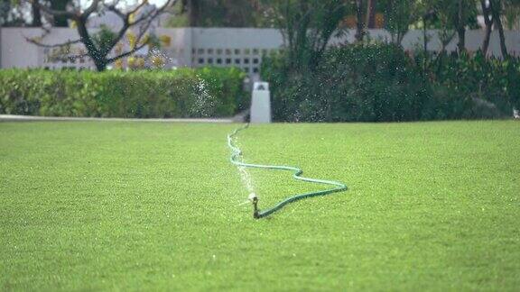 洒水车正在把水喷到后院的草坪上