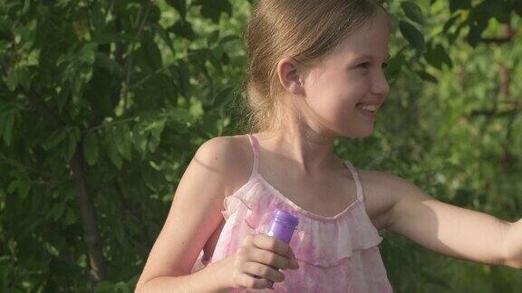 可爱的孩子女孩玩吹肥皂泡在花园阳光灿烂的夏日