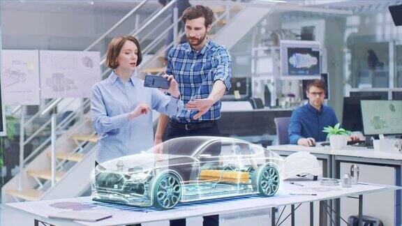 工业设计:从事3D电动汽车设计的汽车工程师和设计师使用智能手机和增强现实图形引擎电池底盘身体收集到完整的车辆